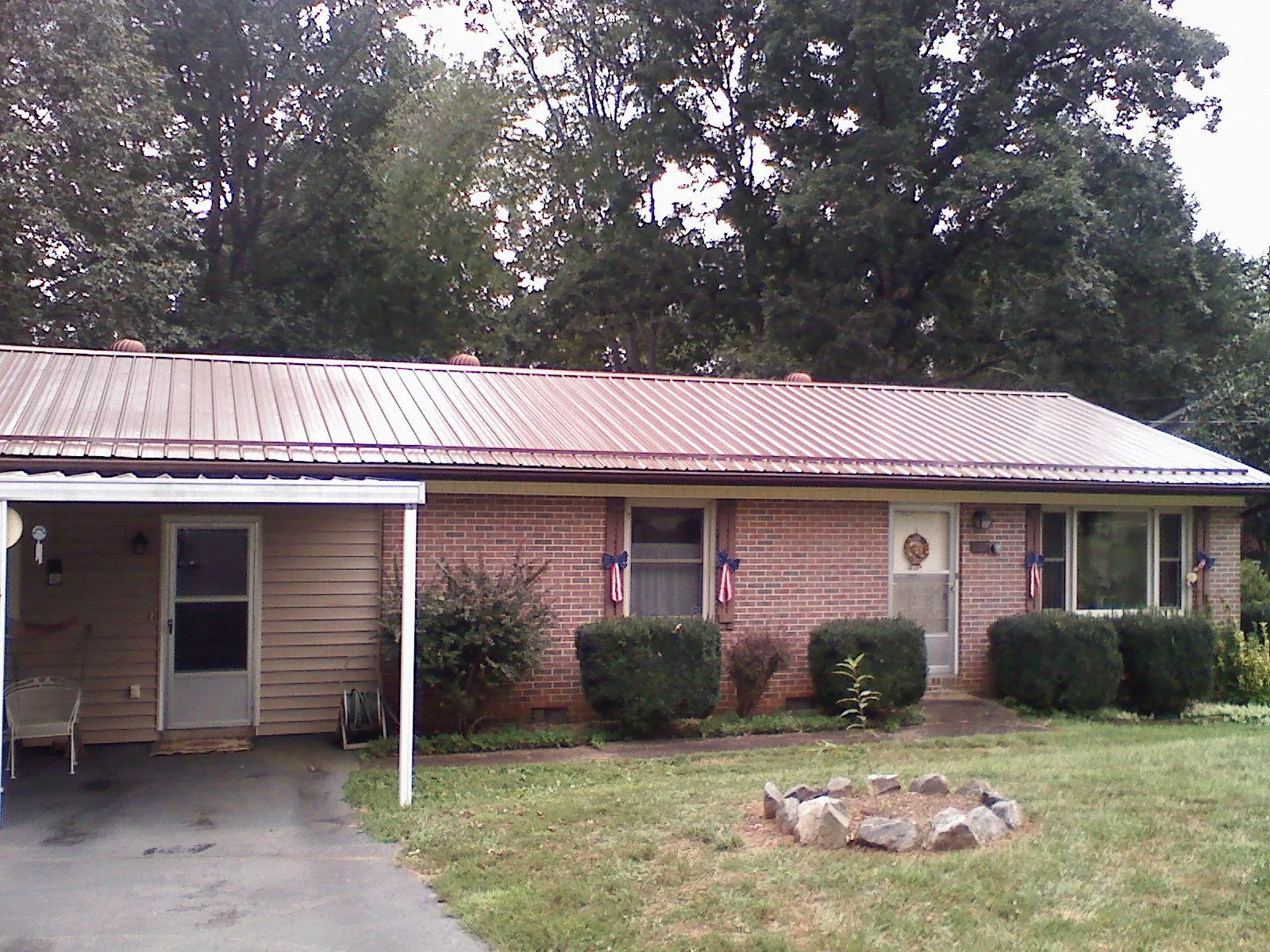 Bronze metal roof and carport on a brick ranch home — Roof Repair work by our crew in Port William